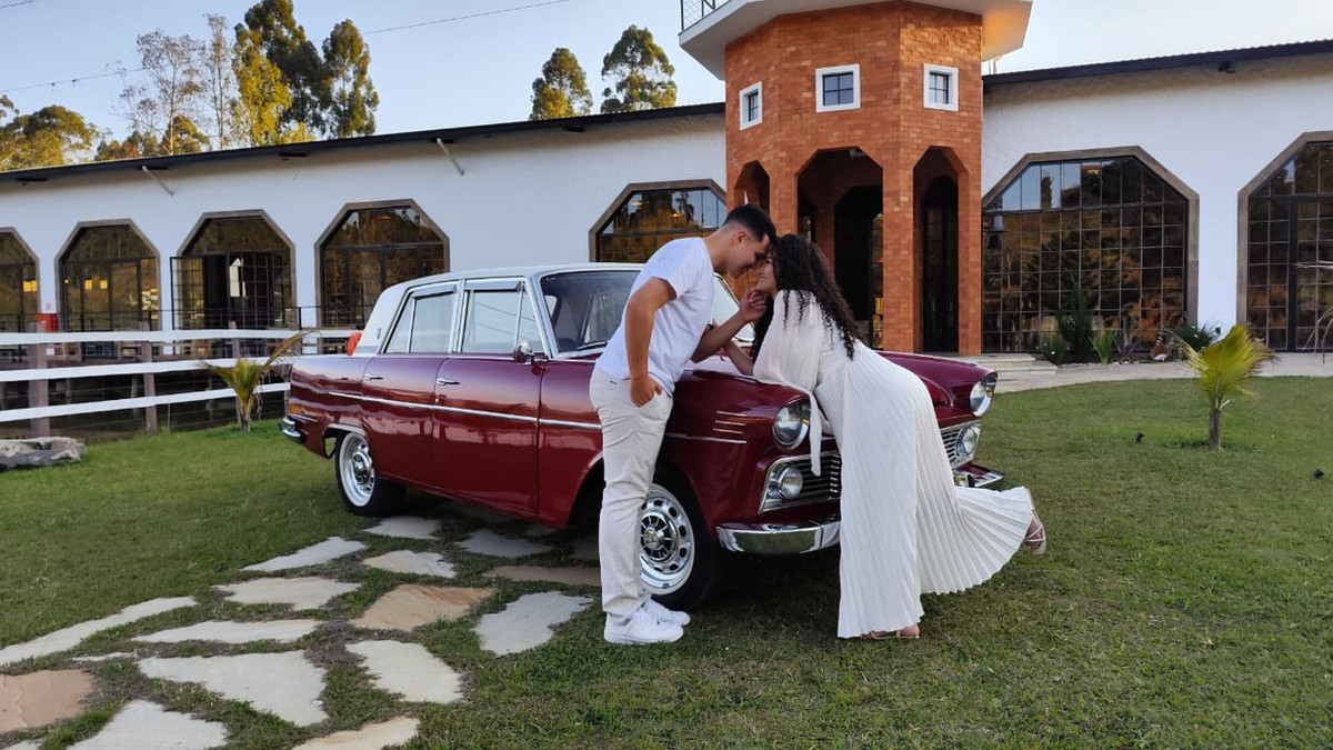 Casal junto ao carro clássico no jardim do Moinho Imperial